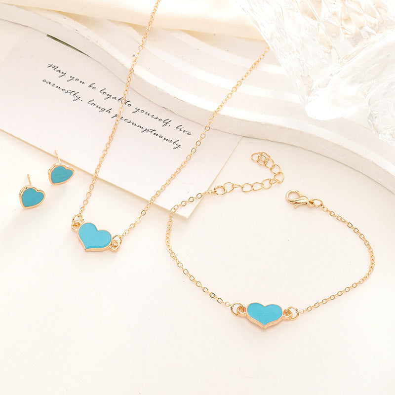 Jewelry set with heart-shaped turquoise stones on gold necklaces and bracelet.