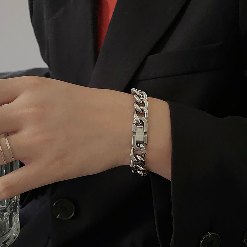 Silver chain bracelet on a person's wrist with a blurred background