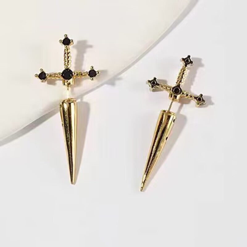 Gold sword-shaped earrings with black gemstones on a white background