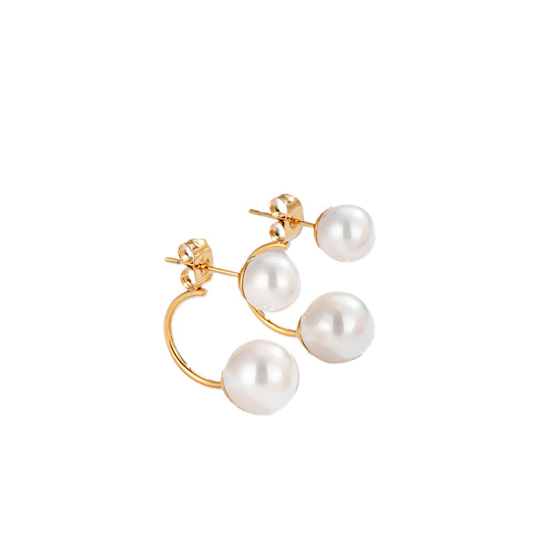 Gold earrings with pearl drops on a white background