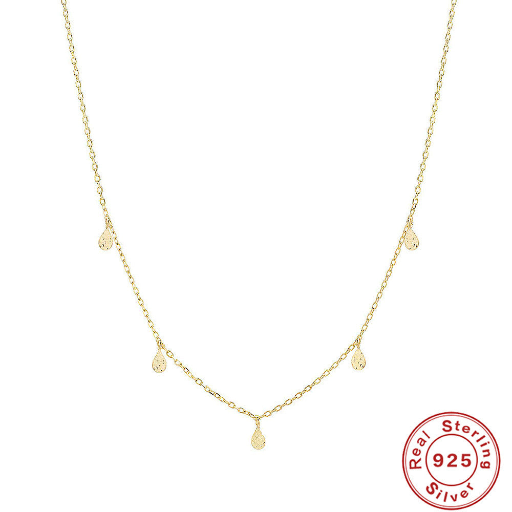 Gold necklace with a teardrop pendant on a white background, featuring a 'Real Sterling Silver 925' stamp.