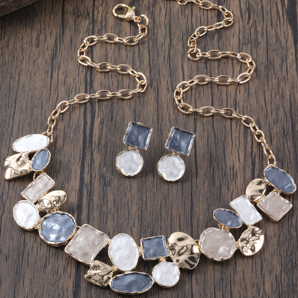 Necklace and earrings with stone accents on a wooden surface