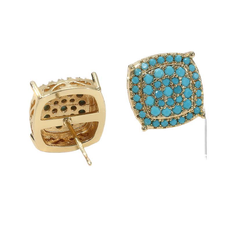 Gold earring with turquoise stones on a white background