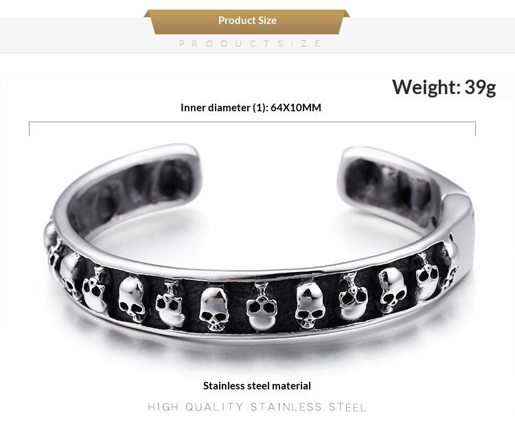 Silver stainless steel cuff bracelet with a row of small skull details on the front, shown with product specifications text on a white background.