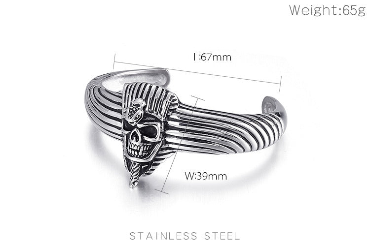 Silver stainless steel cuff ring with a skull and striped wing design, shown with dimension lines and text indicating measurements and weight on a white background.