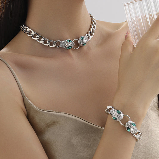 Silver chain necklace and bracelet with green gemstones worn by a person.