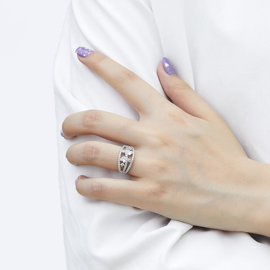 Hand wearing a silver ring with a large gemstone on a white background