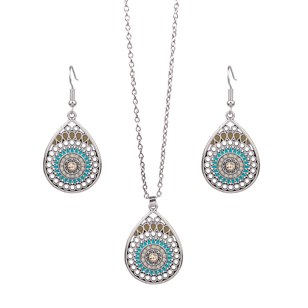 Jewelry set with teardrop-shaped pendants featuring turquoise and silver design on a white background.