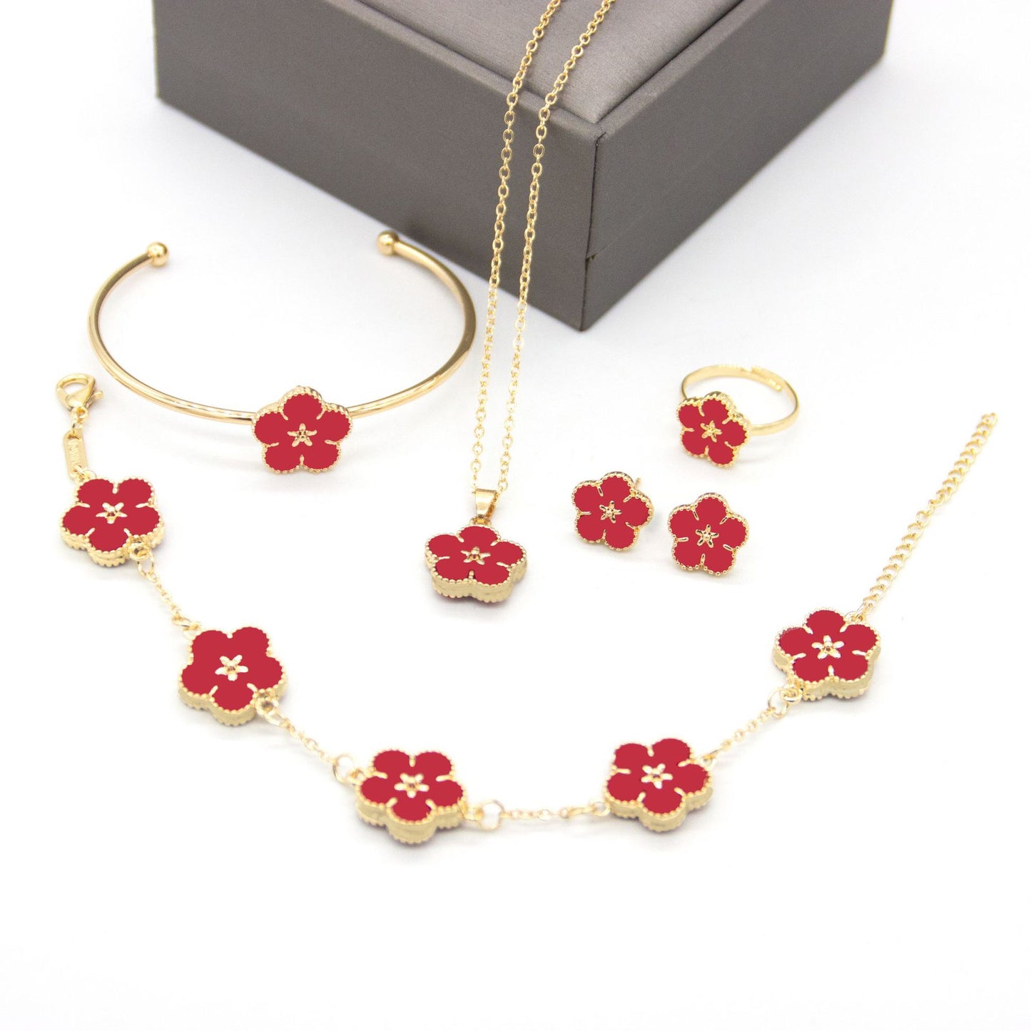 Jewelry set with red flower designs on a white background