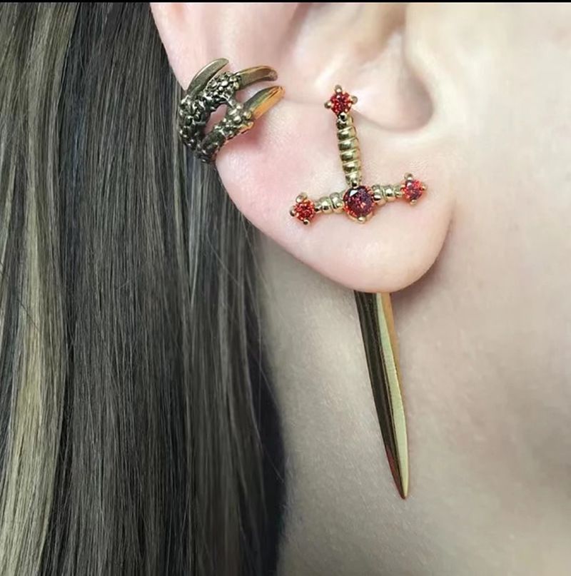 Close-up of an ear with a decorative earring and hair.