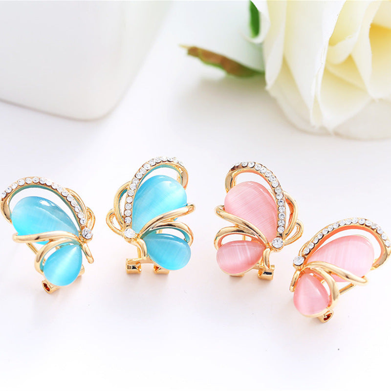 Butterfly-shaped hair clips in blue and pink on a white background with flowers.