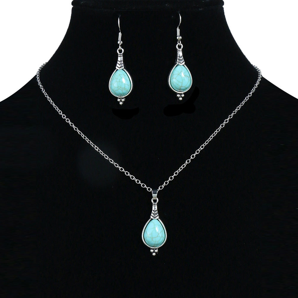Jewelry set with turquoise pendant necklace and earrings on a black mannequin.