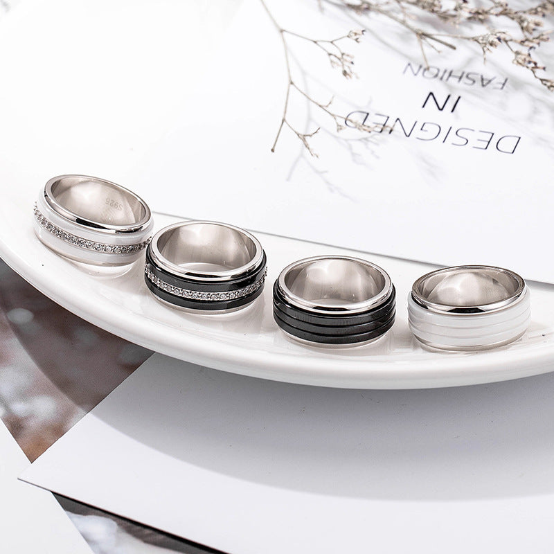 Set of silver and black rings on a white surface with a magazine in the background