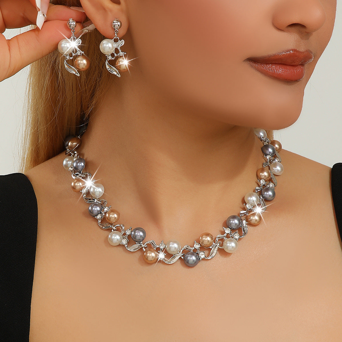Pearl necklace and earrings on a model with a neutral background
