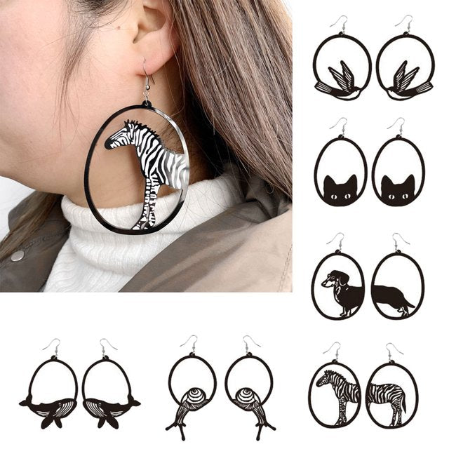 Earrings with animal silhouettes worn by a person, with additional pairs displayed.