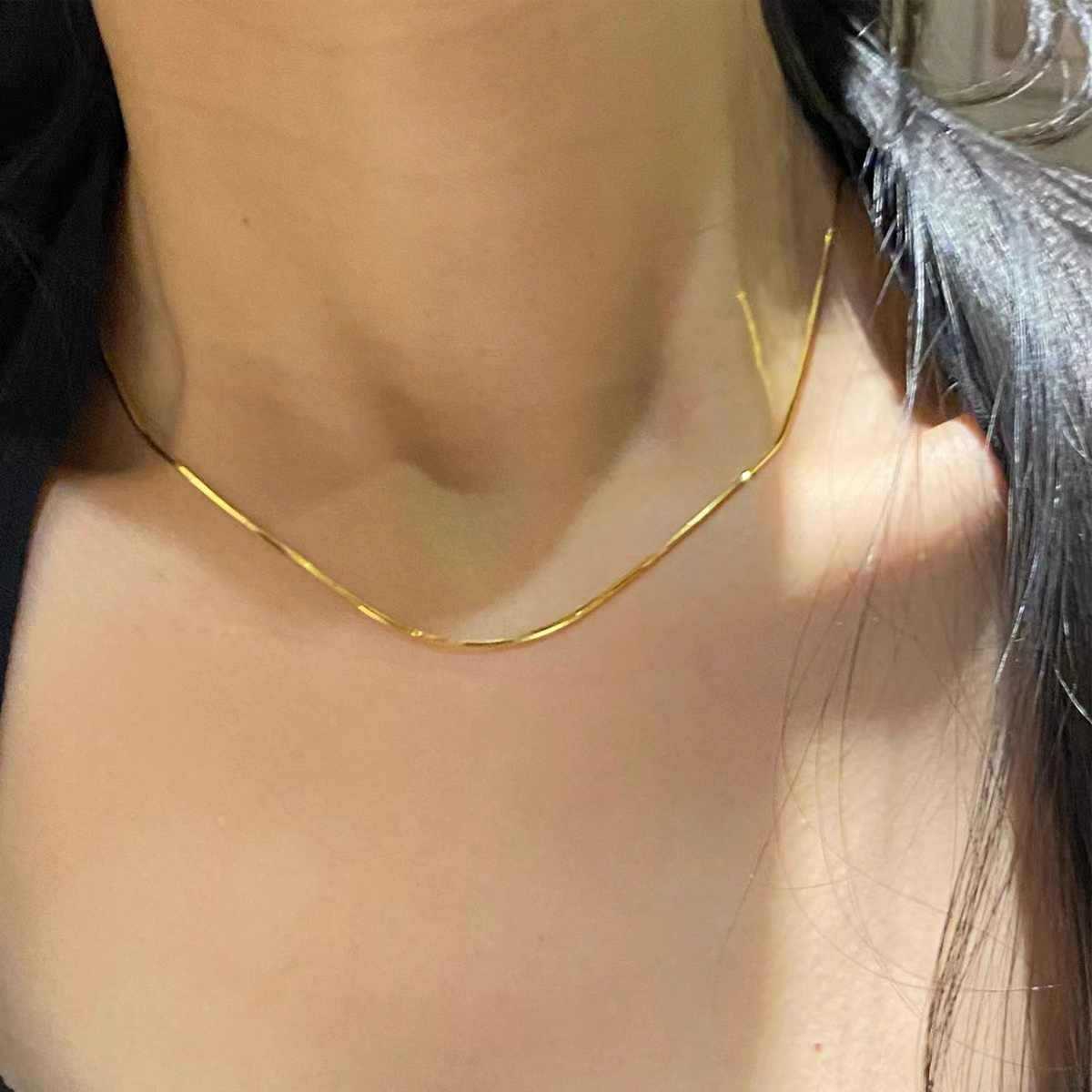 Close-up of a gold necklace on a person with blurred background