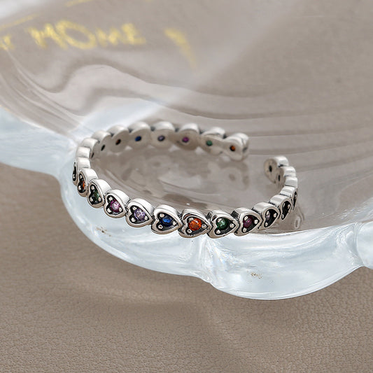 Silver bracelet with heart-shaped gemstones on a shell background