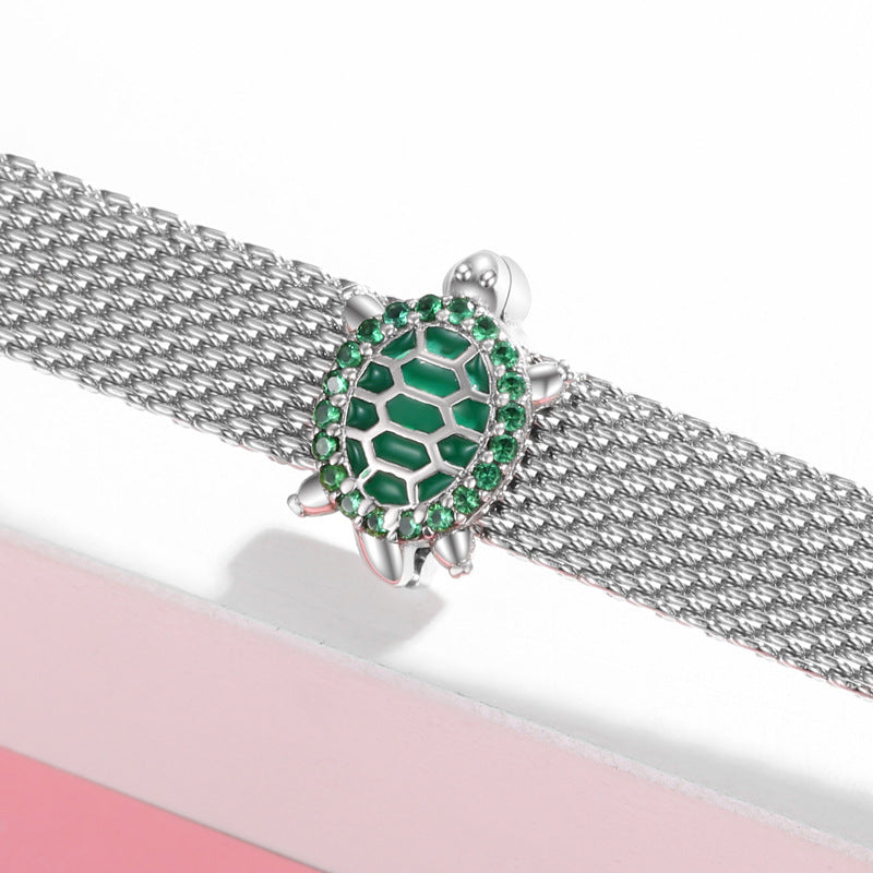 Silver bracelet with a green gemstone turtle clasp on a white background