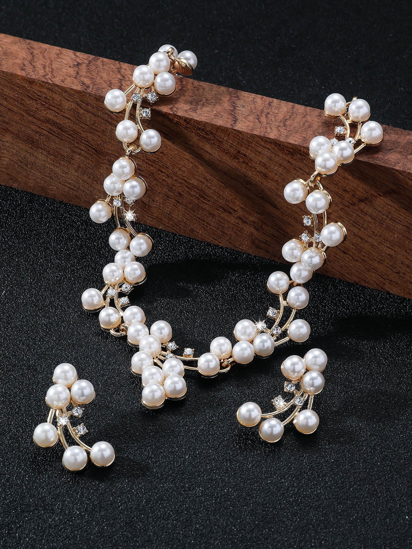 Pearl bracelet on a dark surface with a wooden block