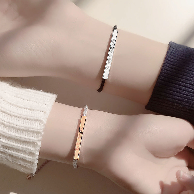 Two bracelets on a wrist with a neutral background