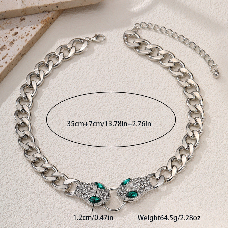 Silver chain necklace with green accents on a light background