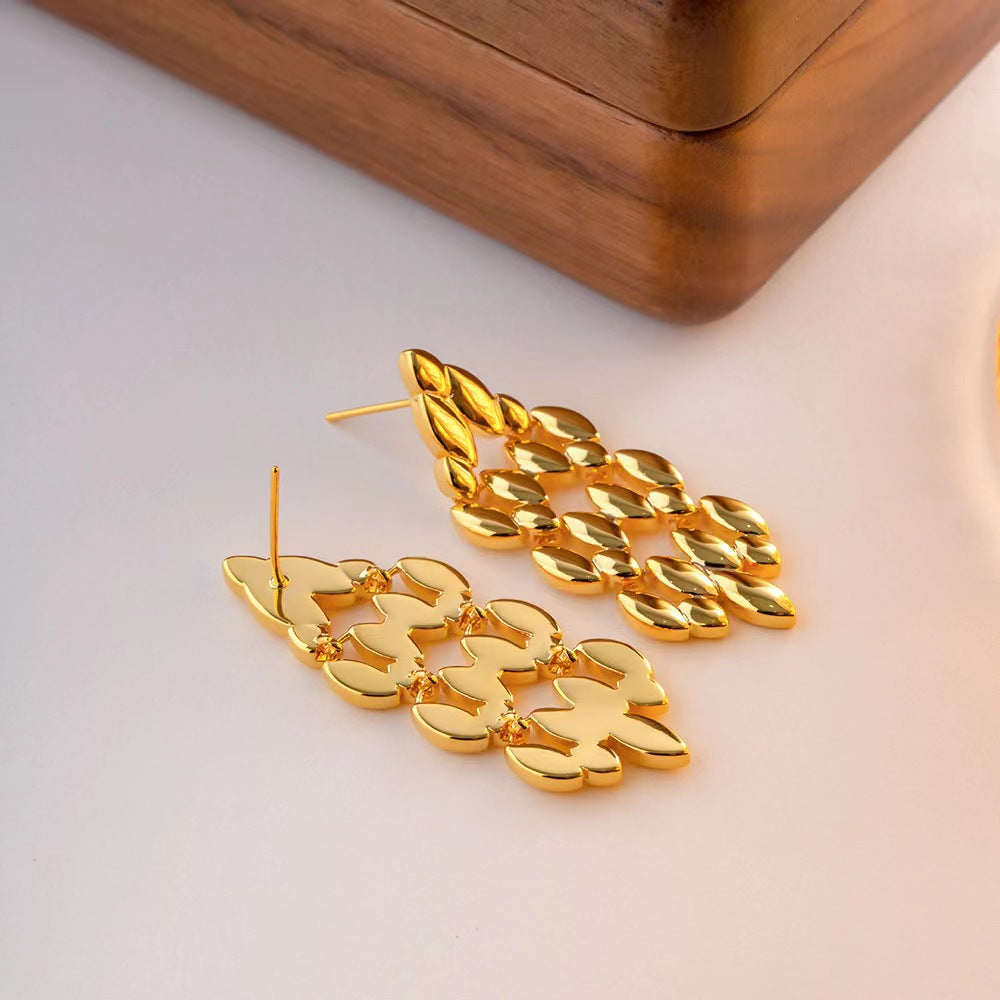 Gold chain earrings on a light background