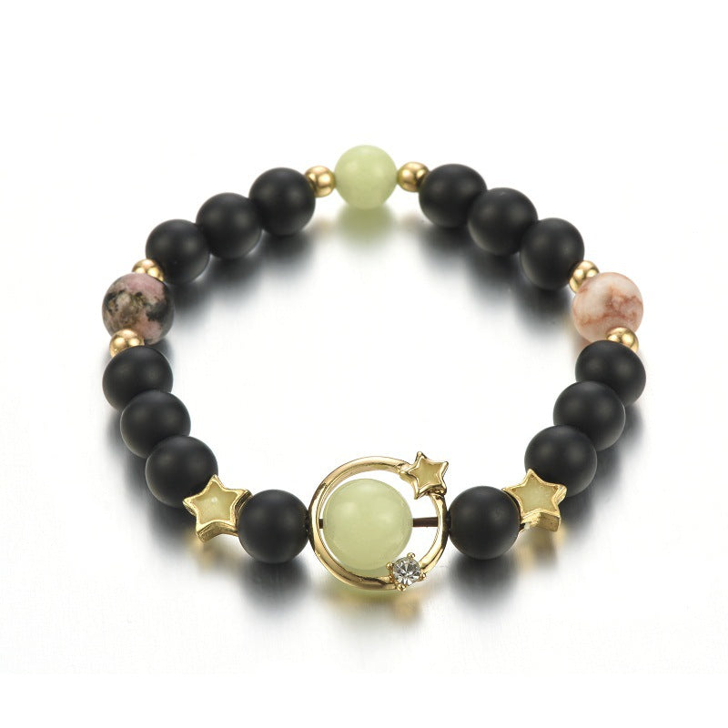 Black beaded bracelet with gold accents and a central green stone on a white background
