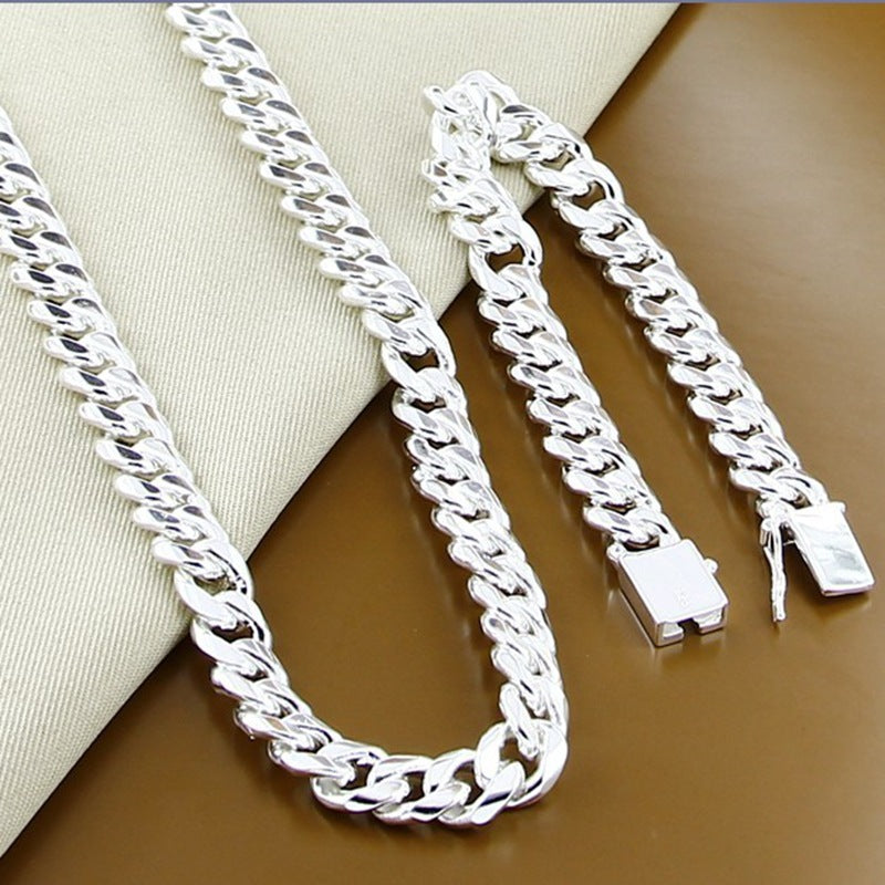 Silver chain necklace with a clasp on a brown surface
