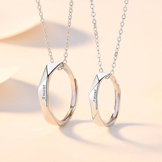 Two silver necklaces with geometric pendants on a soft beige background