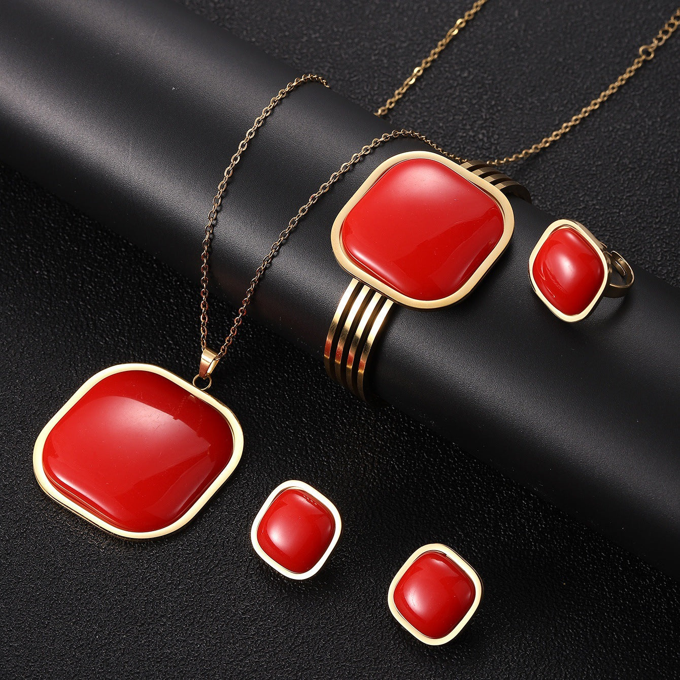 Jewelry set with red stones and gold accents on a black background